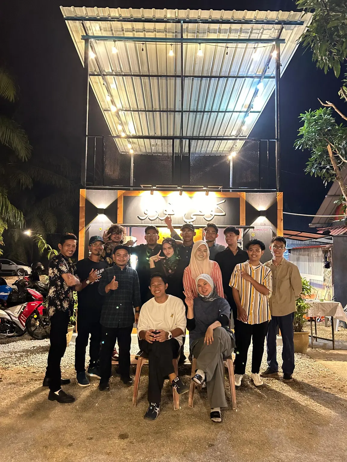 Team gathered outside the storefront at night