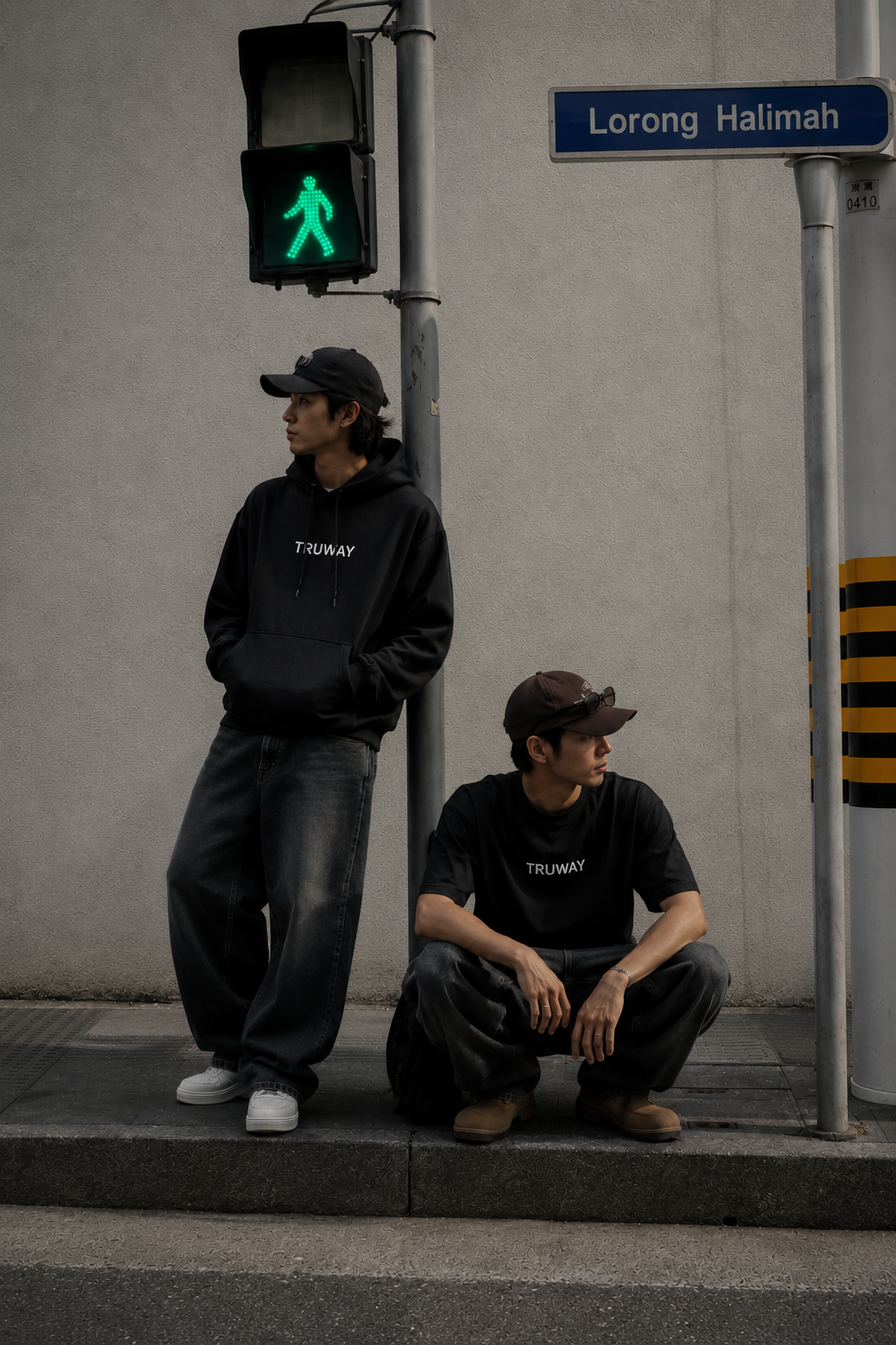 TRUWAY campaign hero — two models wearing the TRUWAY hoodie and tee on a city street corner